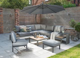 Elba Low Lounge Corner Sofa on patio with footstool and parasol