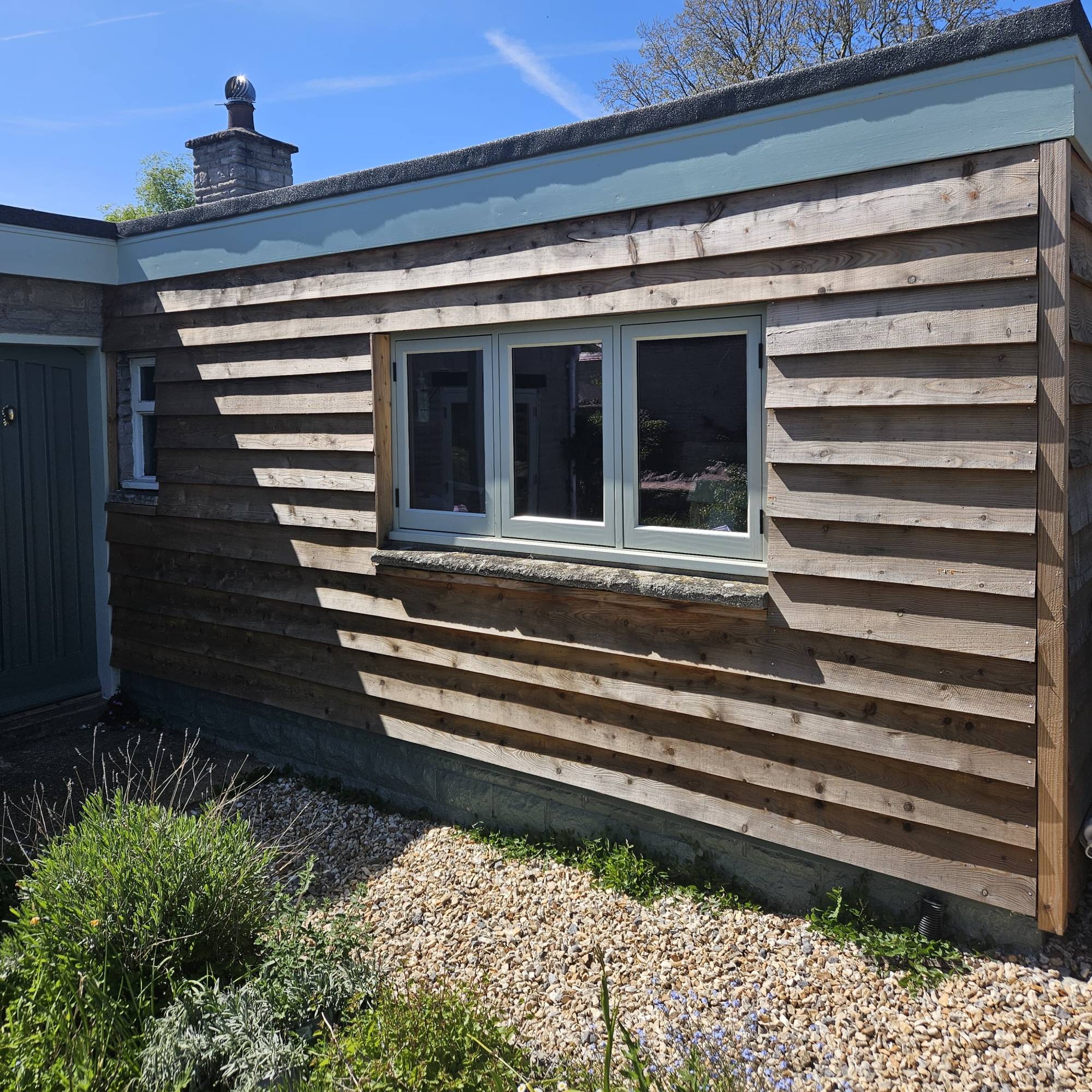 timber cladding on garage with gravel path and garden bed