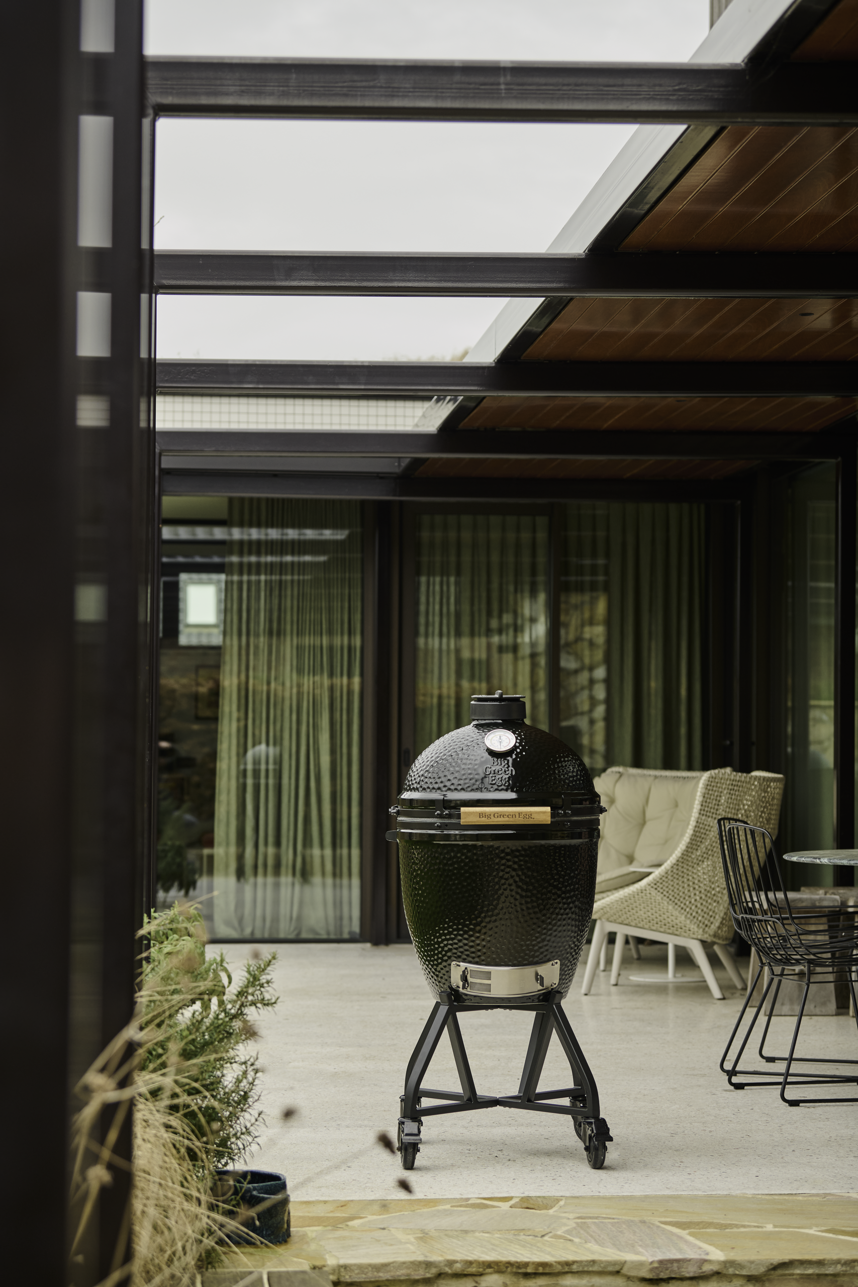 A Big Green Egg grill on a modern, luxurious patio.