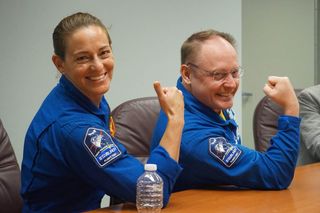 NASA astronauts Nicole Mann (left) and Mike Fincke show off their Starliner Crew Flight Test mission patches ahead of Boeing's uncrewed Starliner Orbital Flight Test launch at the Kennedy Space Center in Cape Canaveral, Florida on Dec. 19, 2019.