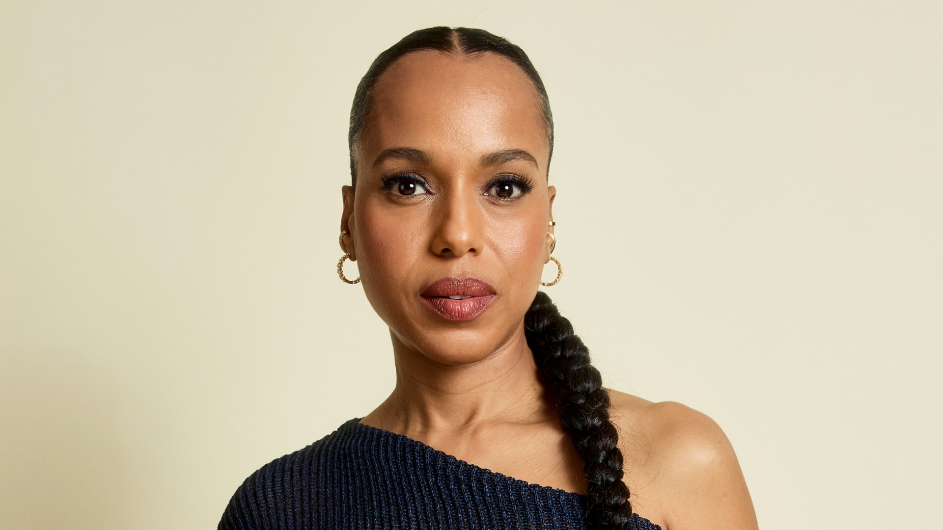 Kerry Washington in an asymetrical top with a low braided ponytail hairstyle 