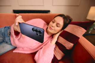 girl lying down and holding a phone horizontally