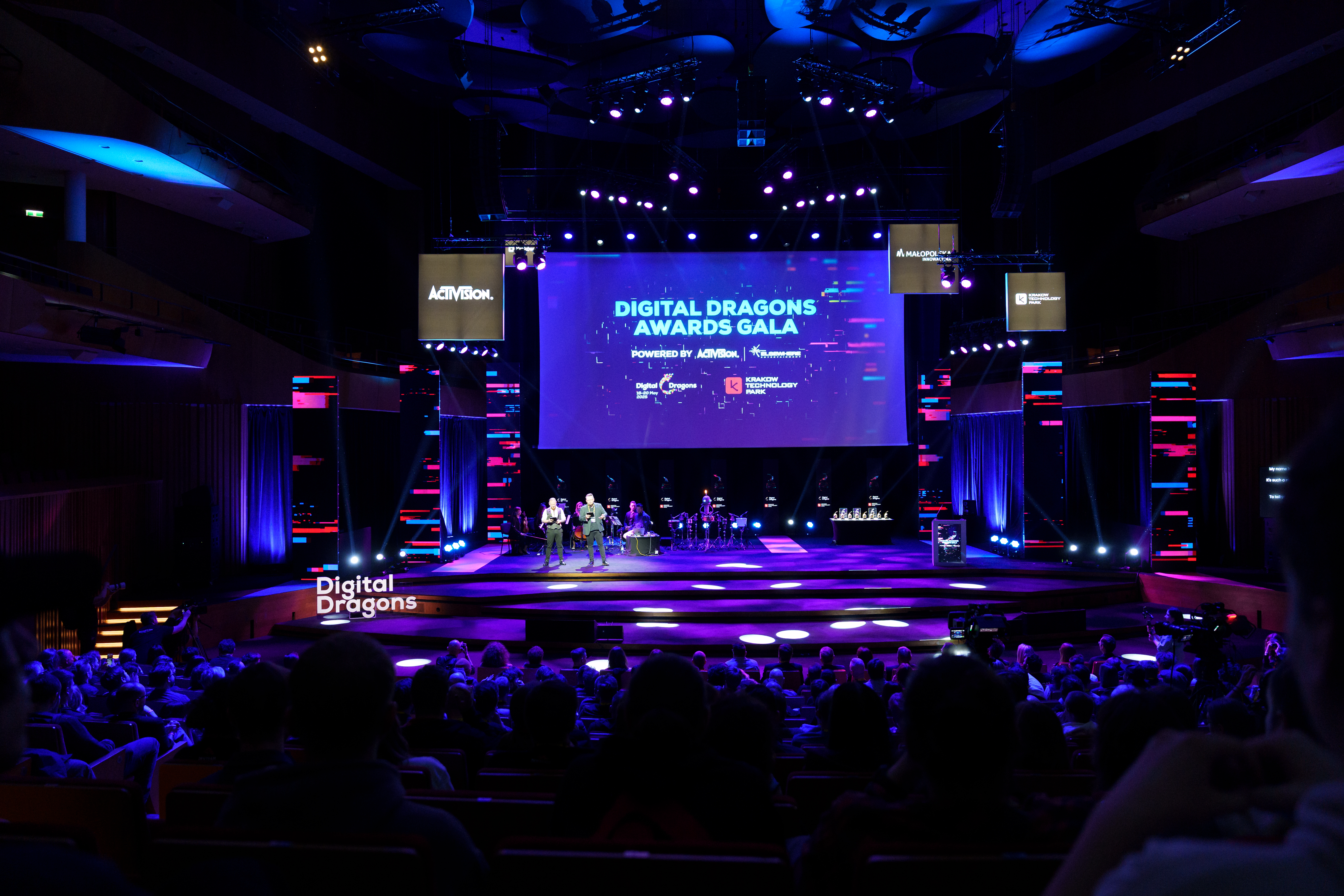 Digital Dragons 2025 photograph of a darkened auditorium, with a projection on the back wall reading Digital Dragons Awards Gala