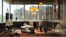 modern living room with chainmail curtain screen, wraparound windows, floating pendant lights, a steel coffee table on a red rug, shelves, sculptural armchairs, and a gilded mirror