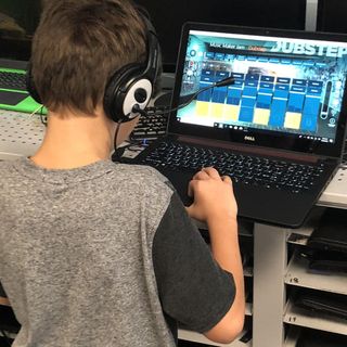 Boy works on laptop computer