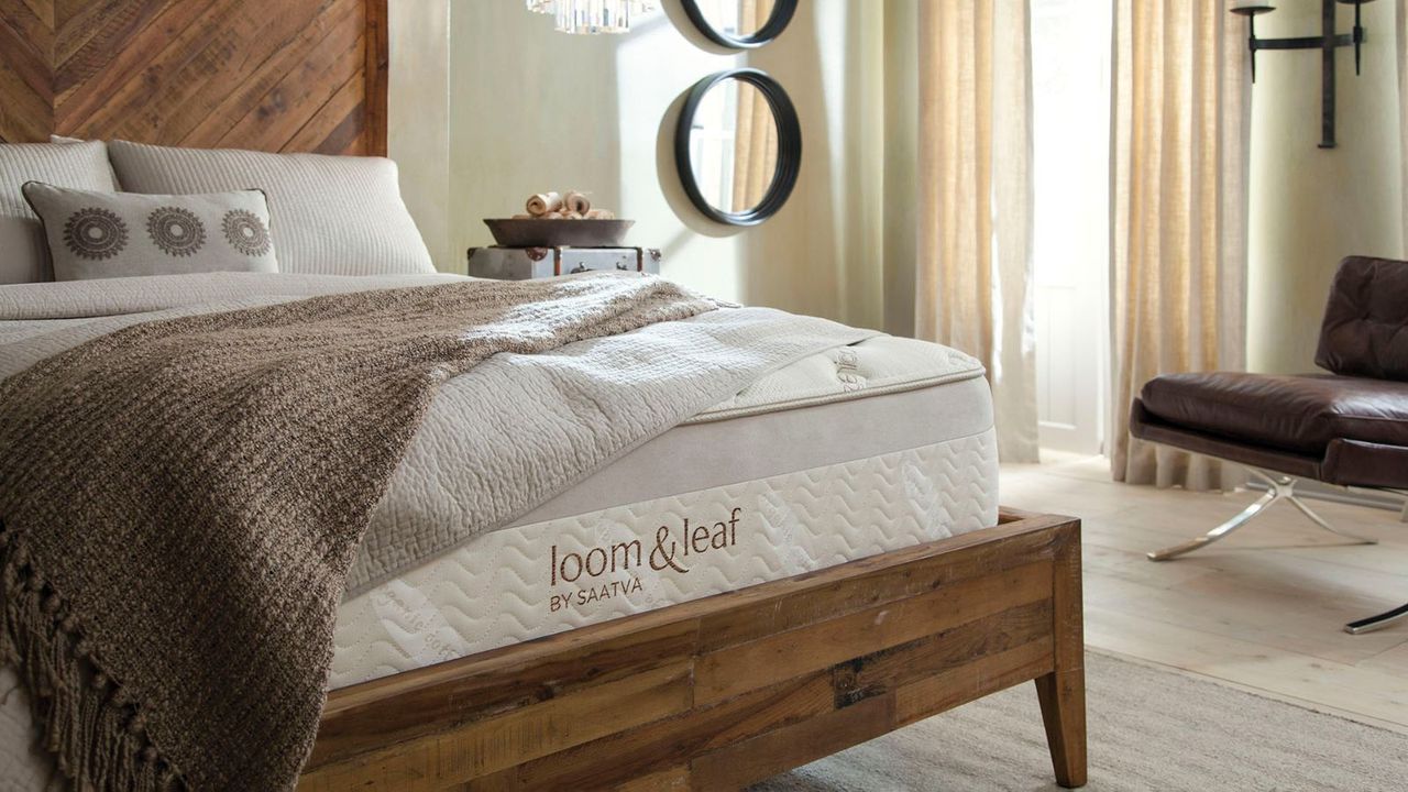 Saatva Loom &amp; Leaf on a bed against cream walls.