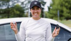 Jess Whitting poses with the golf ball and a BMW car key following her hole in one