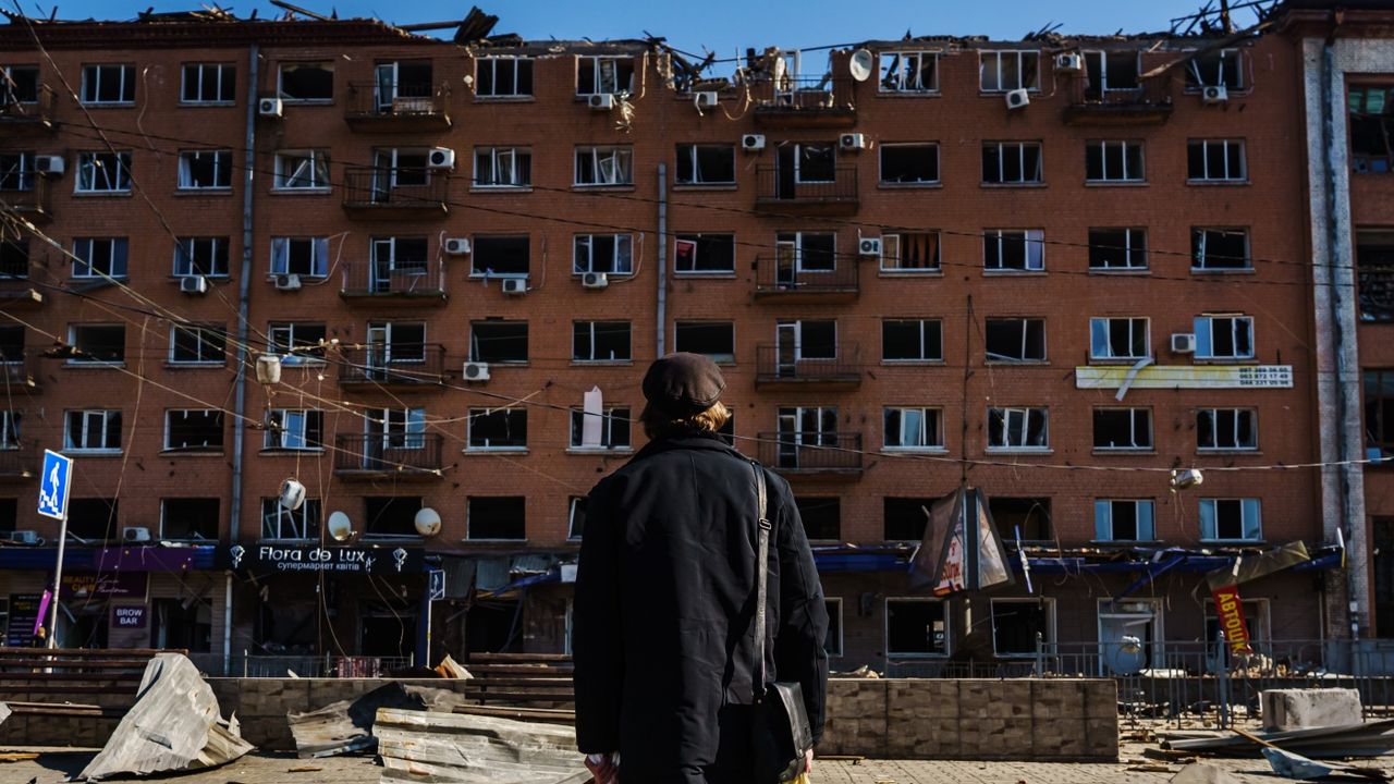 A man inspects the damage to to buildings in Kyiv after a Russian bombardment at the beginning of the war 