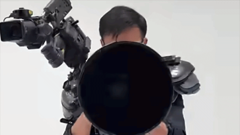 GIF of man in wearable rig operating DJI Ronin 4D and huge Canon 'Big White' lens 