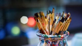 Paint brushes in a glass jar.