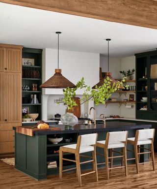 kitchen island color ideas, wood and green kitchen, rattan pendants, green island, black countertop, white countertop on cabinets, open shelving, bar stools, fluted cabinetry,