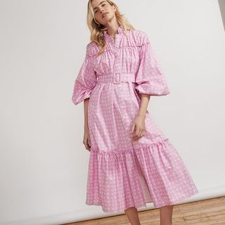 Pink and white midi dress with checked print. The dress has a lower frill and is a button through dress with waist cinching belt and full puff sleeves