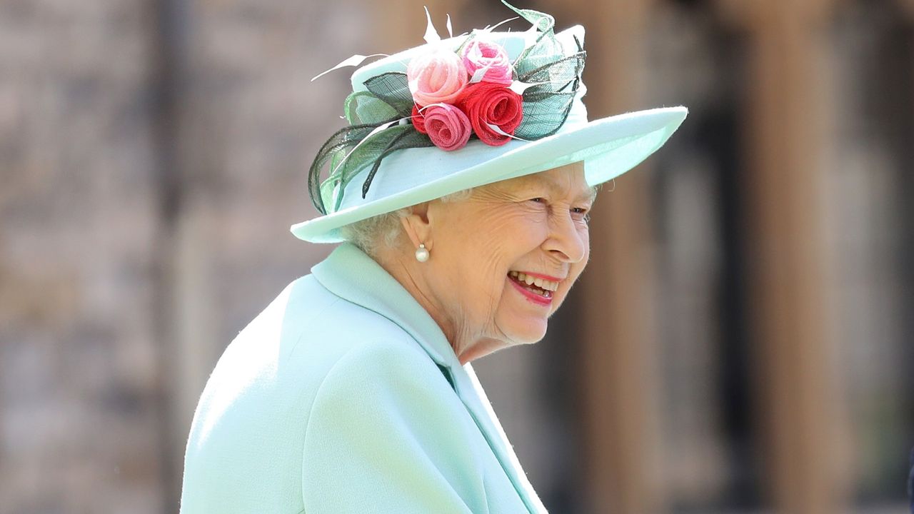 Queen Elizabeth II talks Captain Sir Thomas Moore and his family after awarding him with the insignia of Knight Bachelor at Windsor Castle on July 17, 2020 in Windsor