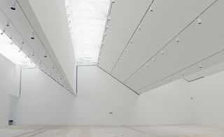 White room with multiple lights hanging from the ceiling