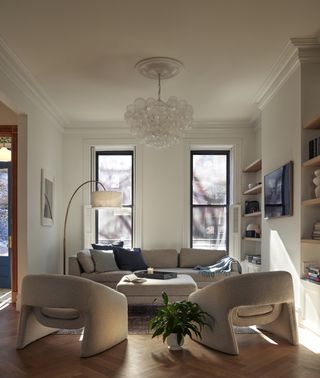 A living room with beige sofas, and a square ottoman-style coffee table