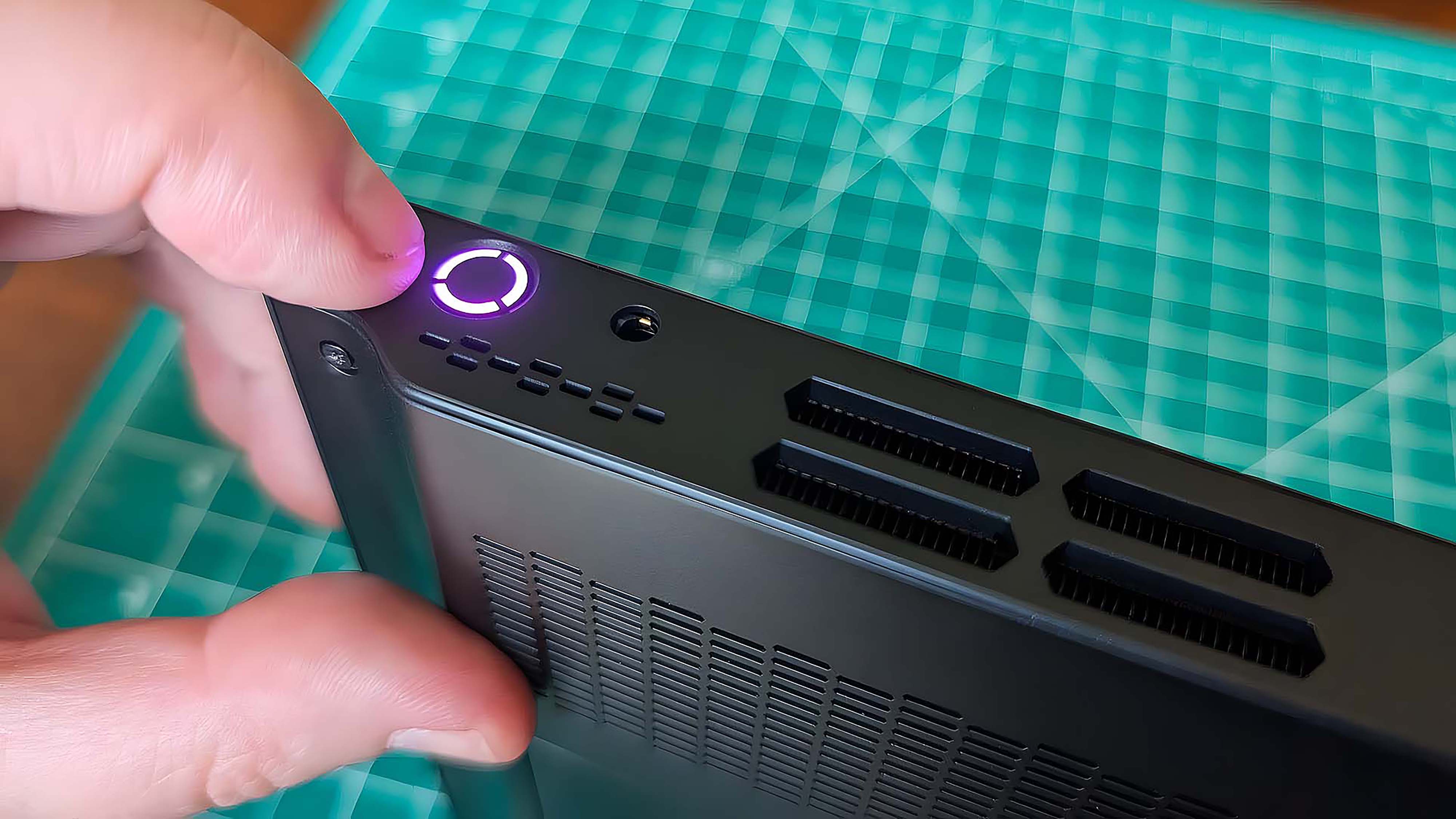 A finger pointing to the Lenovo Legion Go power button.