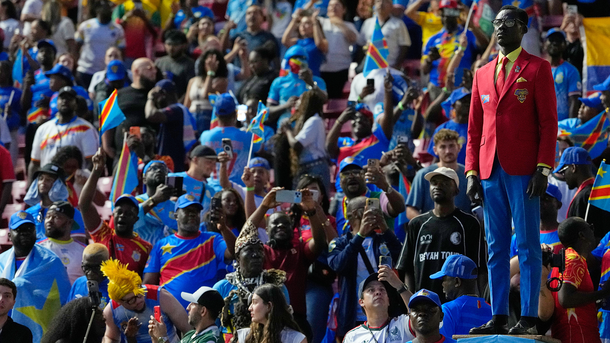 Democratic Republic of Congo supporter Michel Nkuka Mboladinga poses as a statue of Congolese independence hero Patrice Lumumba ahead of the FIFA World Cup match between Colombia and DR Congo in Zapopan, Mexico