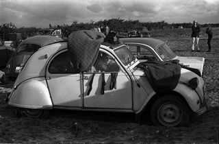 Festival goers camp in a Citroen 2CV car at the Open Air Love And Peace Festival