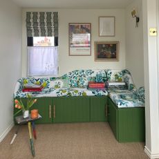 A green corner storage bench made with IKEA BESTA cabinets with a botanical-print seat cushion on top