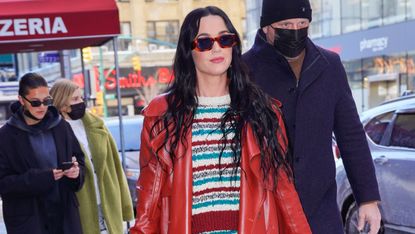 Katy Perry in a striped wool dress, red leather jacket, and red leather boots