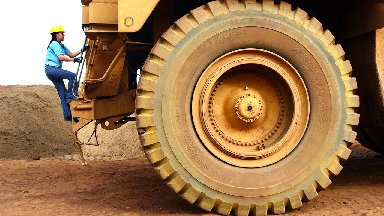 Driver climbing a mine dump truck