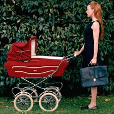 Woman in business attire pushing a pram.