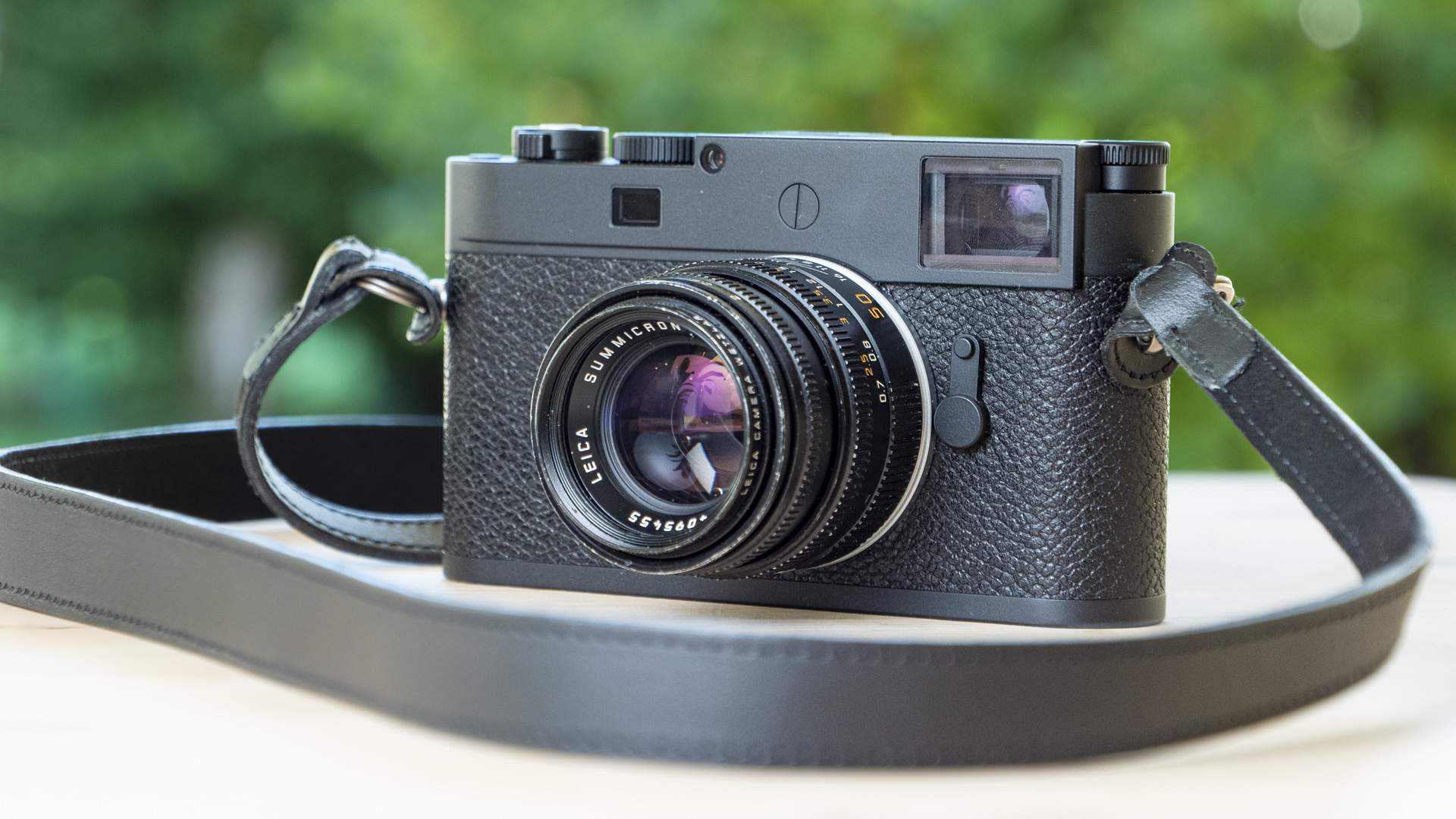 Leica M11-P on wooden table with 50mm f/2 lens attached