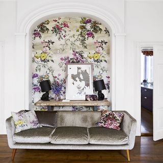living room with floral wallpaper and sofa with cushion