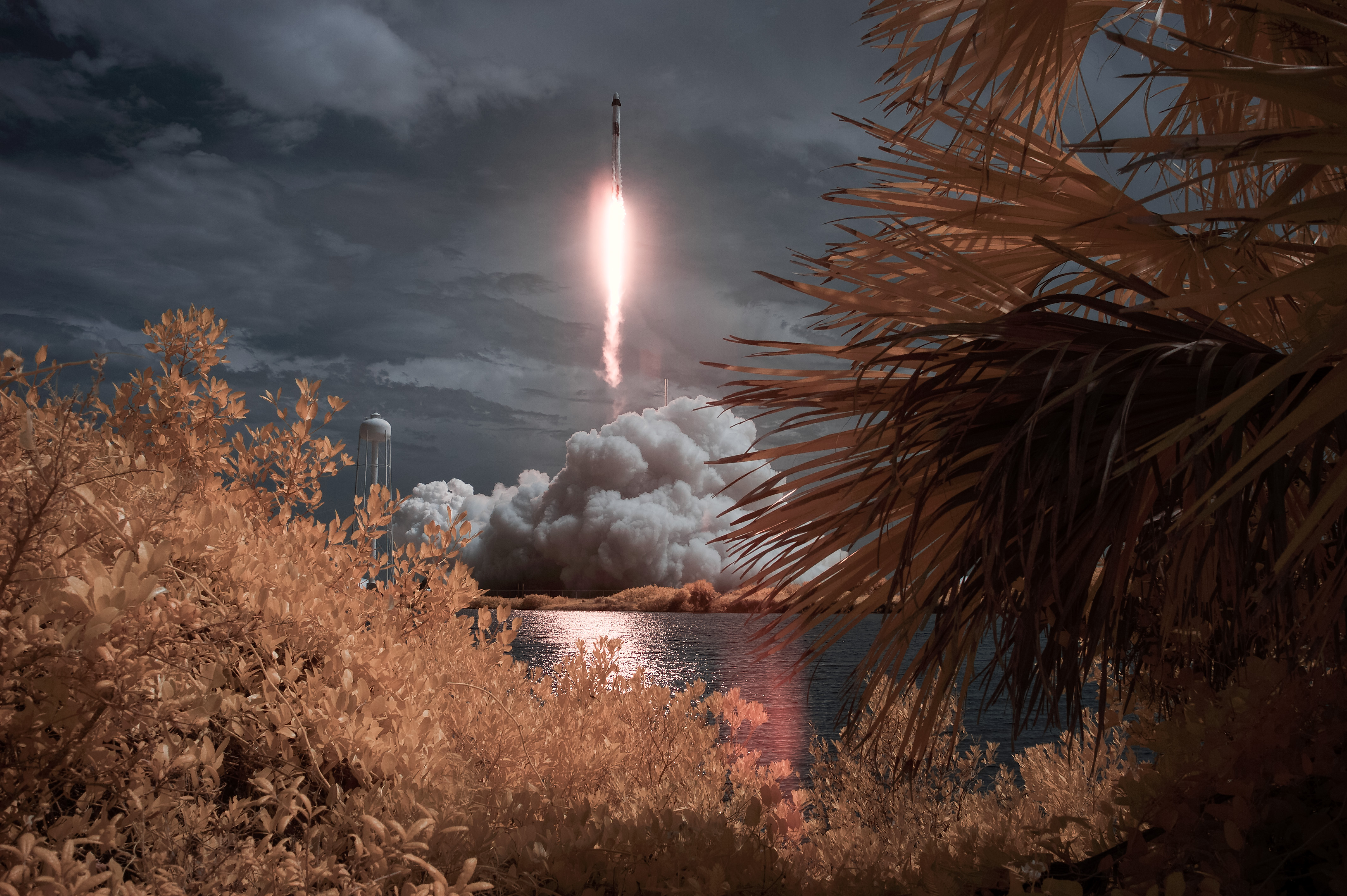 Rakieta SpaceX Falcon 9 niosąca statek kosmiczny firmy Crew Dragon jest widoczna w tej fałszywej ekspozycji na podczerwień, gdy wystrzeliwana jest podczas misji NASA SpaceX Demo-2 na Międzynarodową Stację Kosmiczną z astronautami NASA Robertem Behnkenem i Douglasem Hurleyem na pokładzie, sobota, 30 maja , 2020, w NASA Kennedy Space Center na Florydzie.