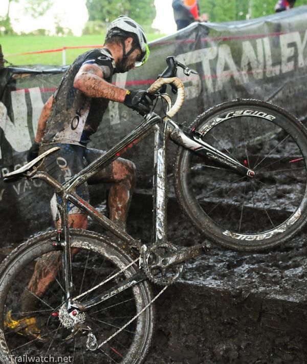 An Orbea rider using a one-handed technique to get his bike up the steps