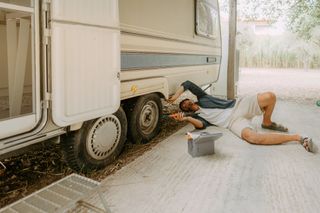 Photo of a young man repairing and checking his recreational vehicle..