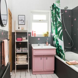 bathroom with grey and white wall and pink washbasin and bathtub