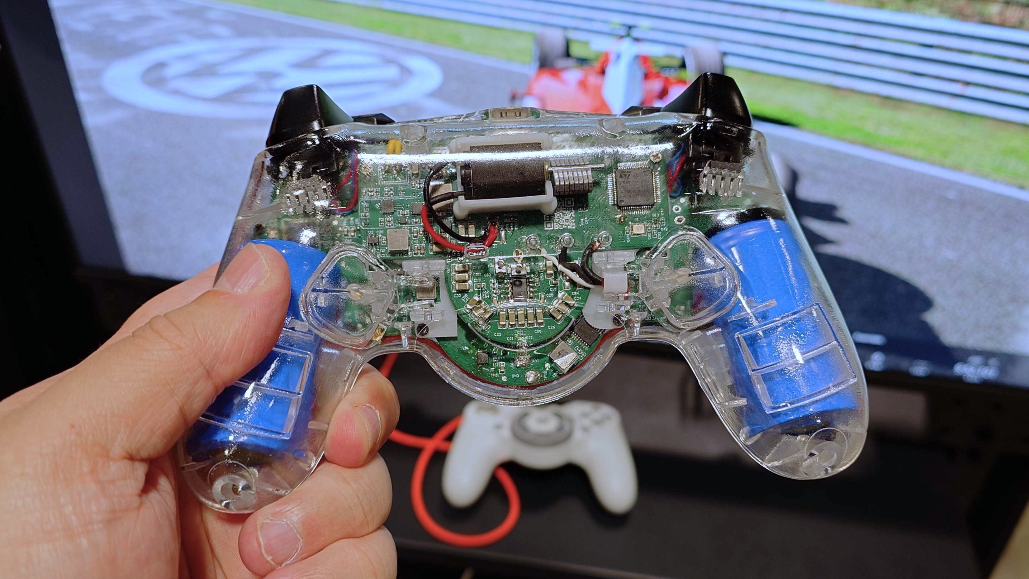 A photo of the GameSir Swift Drive controller with a see-through case showcasing the batteries, circuit board and components.