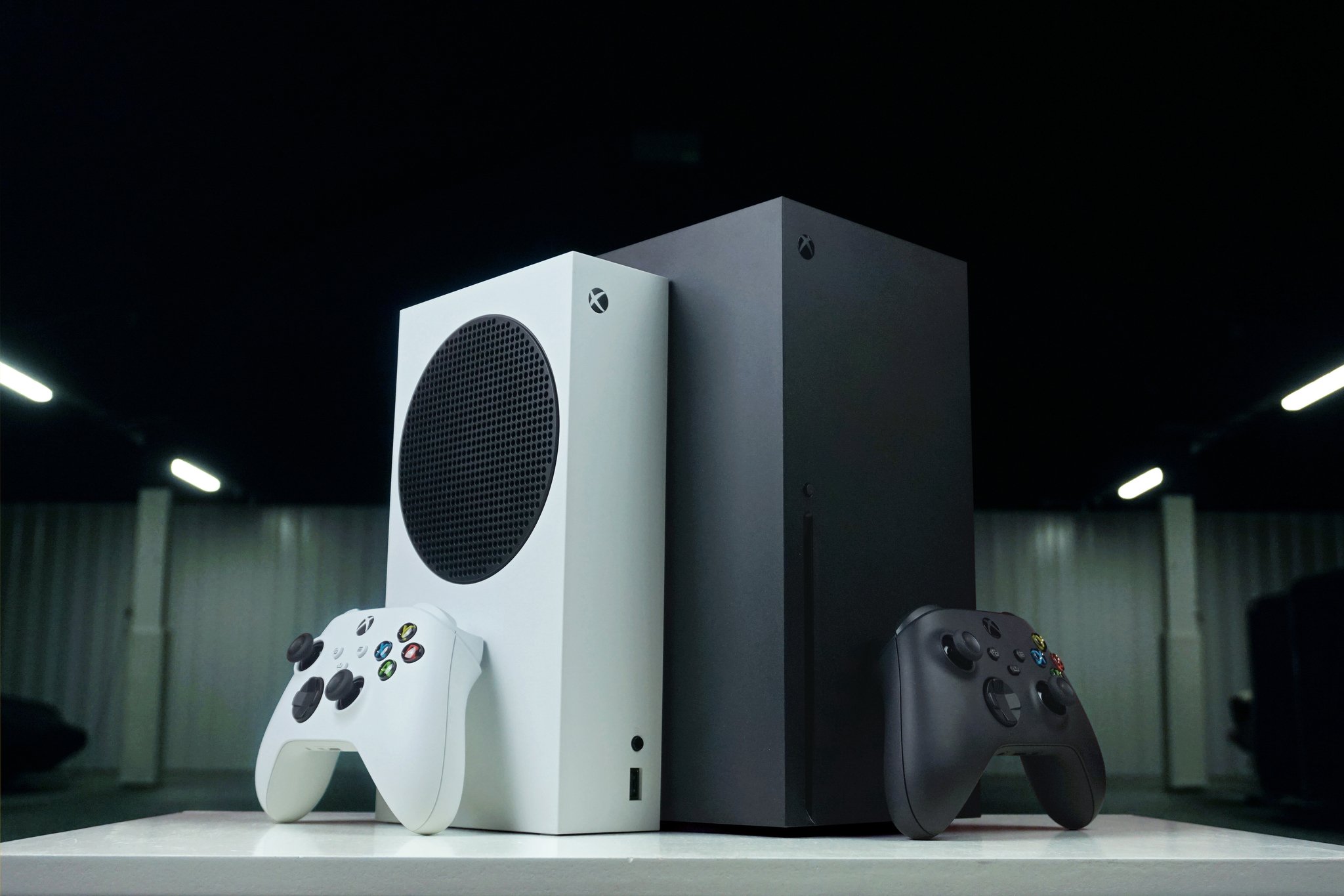Imagen de Xbox Series X y Series S una al lado de la otra con controles inalámbricos Xbox.