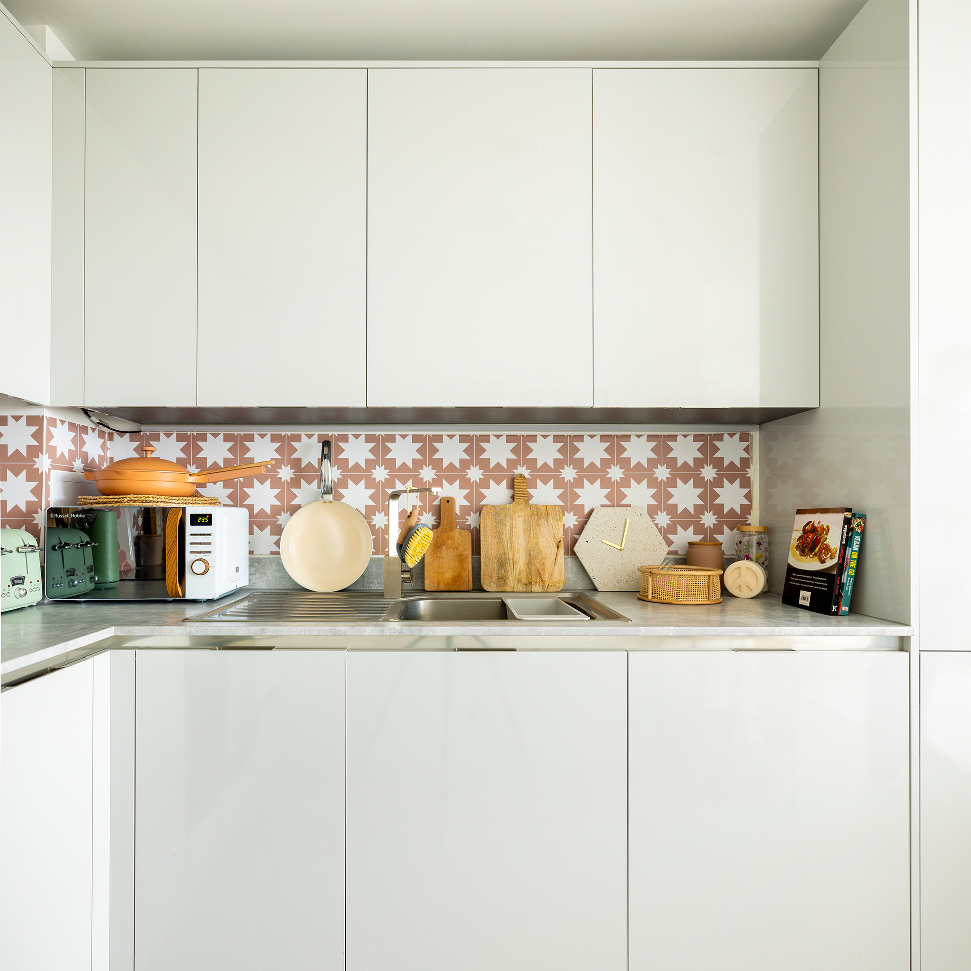 White kitchen with pink tiles splashback