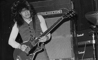 Malcolm Young performs onstage with AC/DC at the Marquee club in London on May 12, 1976