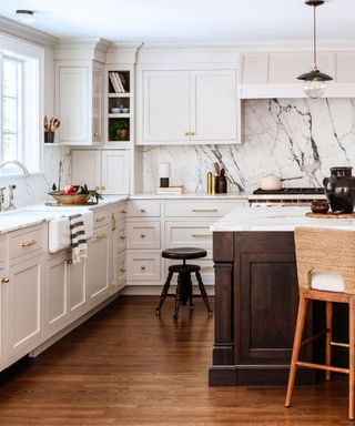 White shaker-style kitchen with marble worktops and a wooden island