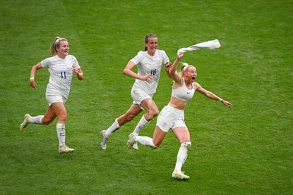 Womens Euro 22: LONDON, ENGLAND - JULY 31: Chloe Kelly of England celebrates scoring the winning goal with team mates Lauren Hemp and Jill Scott during the UEFA Women's Euro 2022 final match between England and Germany at Wembley Stadium on July 31, 2022 in London, England. (Photo by Michael Regan/Getty Images)