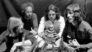 The members of the Doors sitting around a small clay figurine