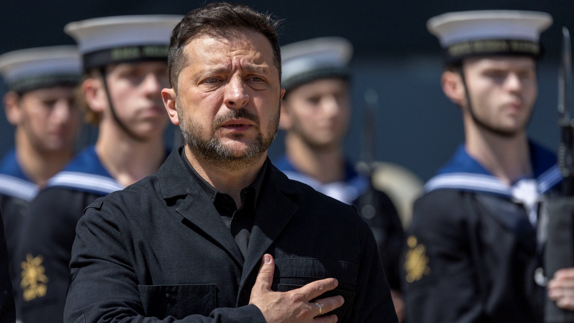 Zelenskyy looking worried, holding his hand over his heart