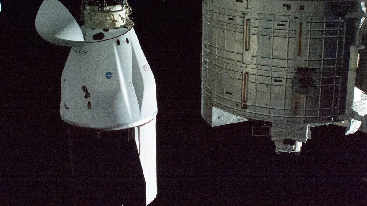 SpaceX&#039;s Dragon CRS-21 cargo resupply ship is pictured docked to the International Space Station&#039;s Harmony module. At right, a portion of the JAXA Kibo laboratory module is pictured.