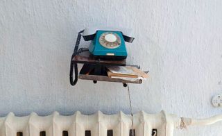Blue telephone above a radiator