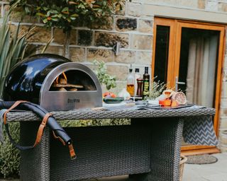 A tabletop pizza oven on an outdoor cooking station