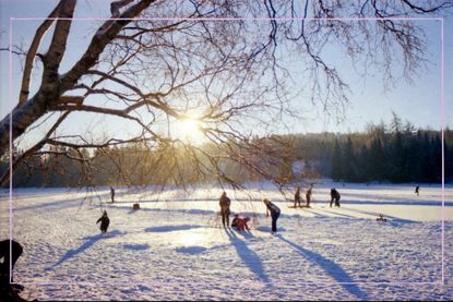 A field covered in snow with people playing in it