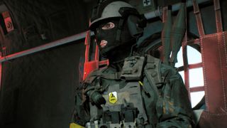 Battlefield Redsec custom weapon loadouts: A Pax Armata soldier wearing armour and a balaclava sat inside a helicopter, waiting to airdrop.