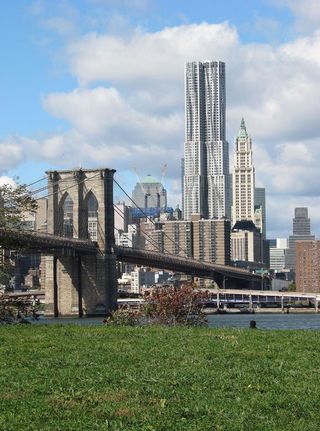 One of New York's most iconic towers, 8 Spruce Street. A large white building with a bridge in front of it.