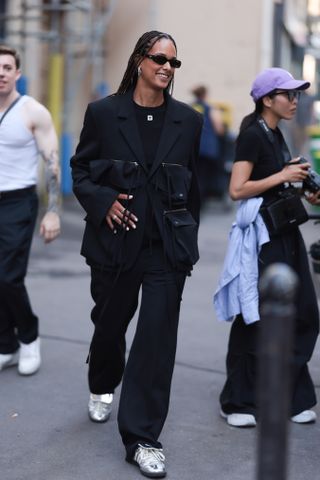 Woman wearing silver Adidas Wales Bonner sneakers with black jeans.