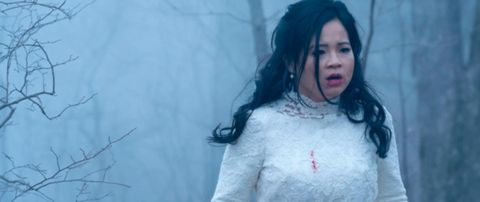 In Hulu's Monsterland Kelly Marie Tran wears a blood smeared white wedding dress in a dark forest