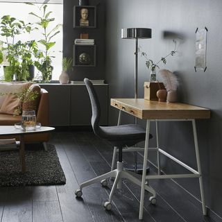 living room with grey walls wooden flooring bamboo work desk and brown sofa sets