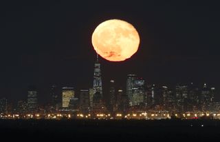 The moon rises behind lower Manhattan on Oct. 25, 2018, the day after the full Hunter's Moon.